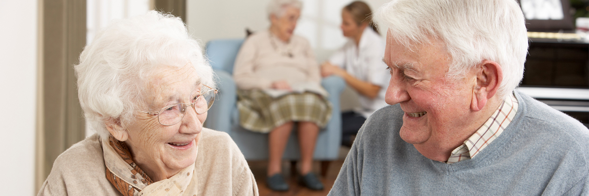 elderly couple smiling with patient in background